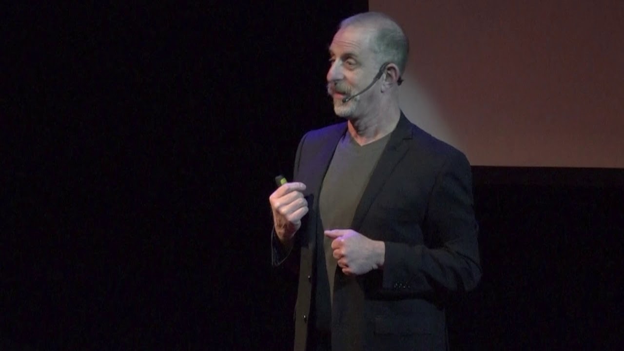 Ian Gold in a suit giving a talk